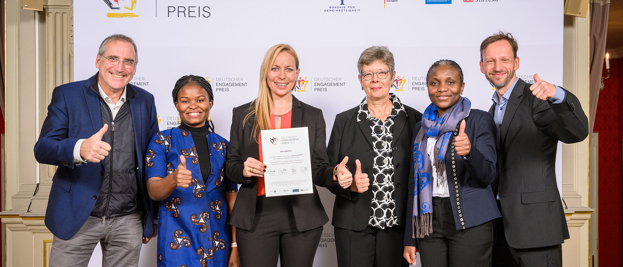 Engagierte von Africademics vor der Pressewand mit der Laudatorin Maiouma Ouattara und Jan Wenzel 