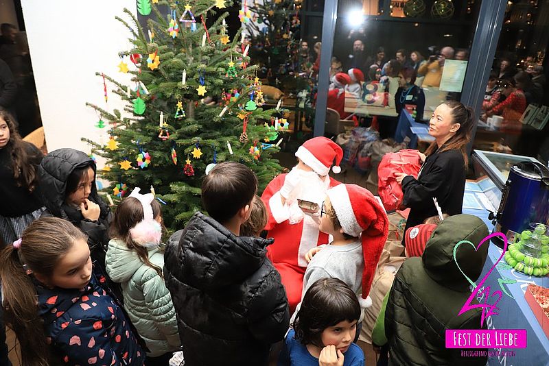 Verkleideter Weihnachtsmann verteilt Geschenke an Kinder
