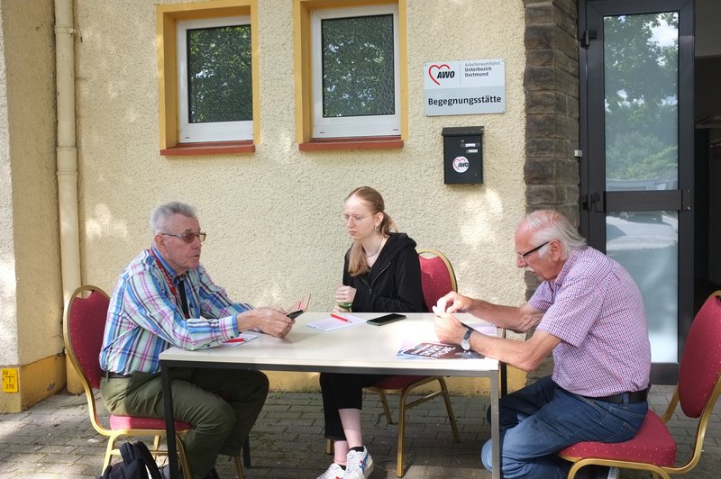 Junge Frau erklärt älteren Herren das Handy