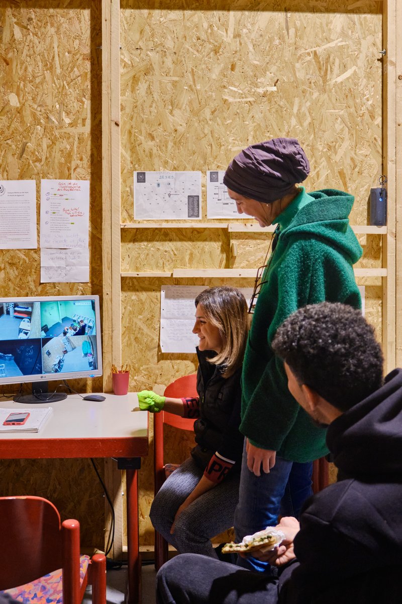 Marjan, Nadja und Hussein beobachten eine Spielgruppe vom Regieraum aus.