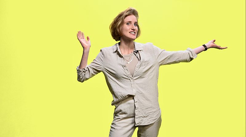 Franzi von easy newstime begrüßt Menschen vor grünem Hintergrund