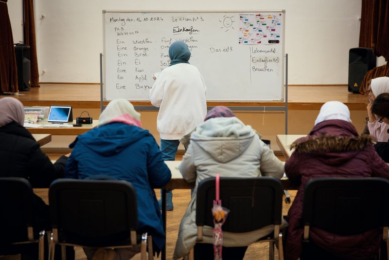 Ehrenamtliche und Schülerinnen sowie Familien feiern gemeinsam beim Sommerfest.