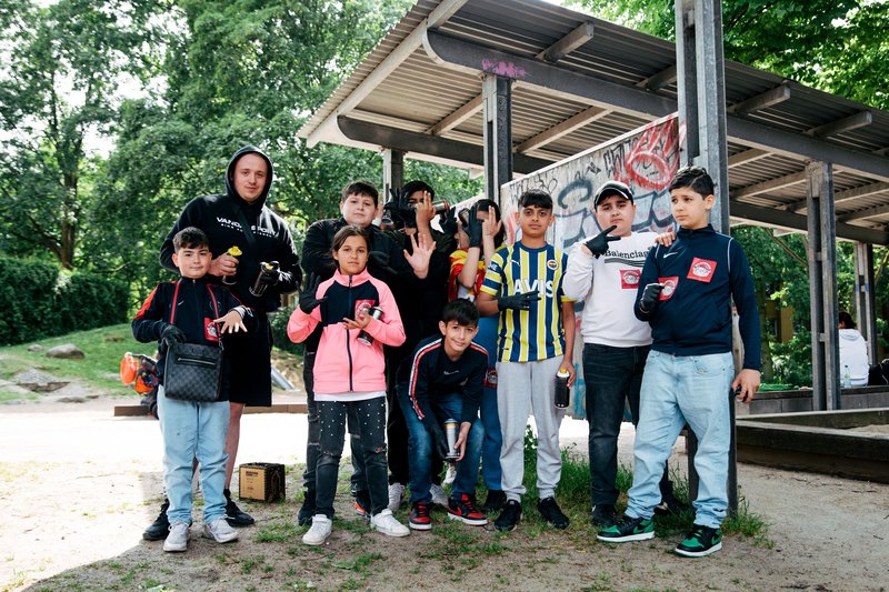 Kids und ehrenamtlicher Dozent beim Sprayen