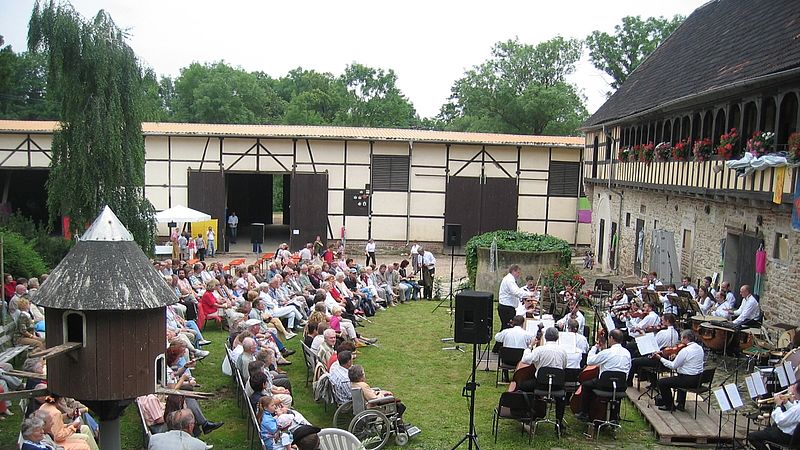 Zuschauer eines Konzertes vor Fachwerkhäusern