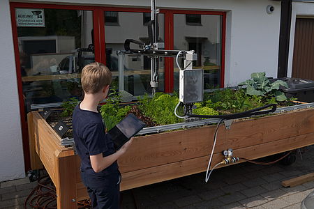 ein Farmbot der autonom die Pflanzen eines Hochbeets bewirtschaftet