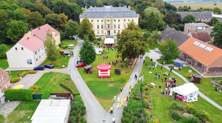 Menschen machen eine Pause von ihrem Arbeitseinsatz im Park und stehen in einer Gruppe an einem Auto.