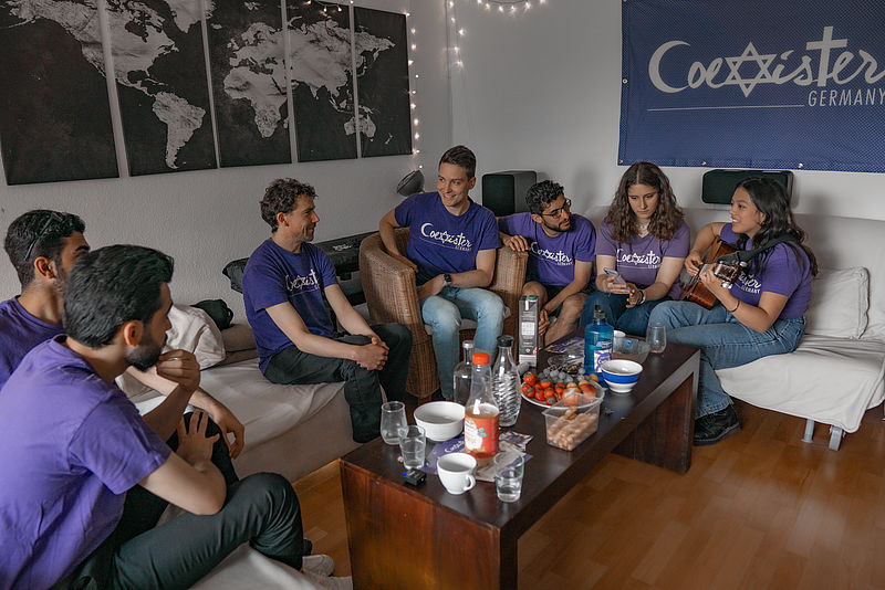 Junge Menschen sitzen und singen gemeinsam