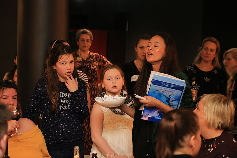 Eine Gruppe Kinder singt und verteilt Tombola-Lose