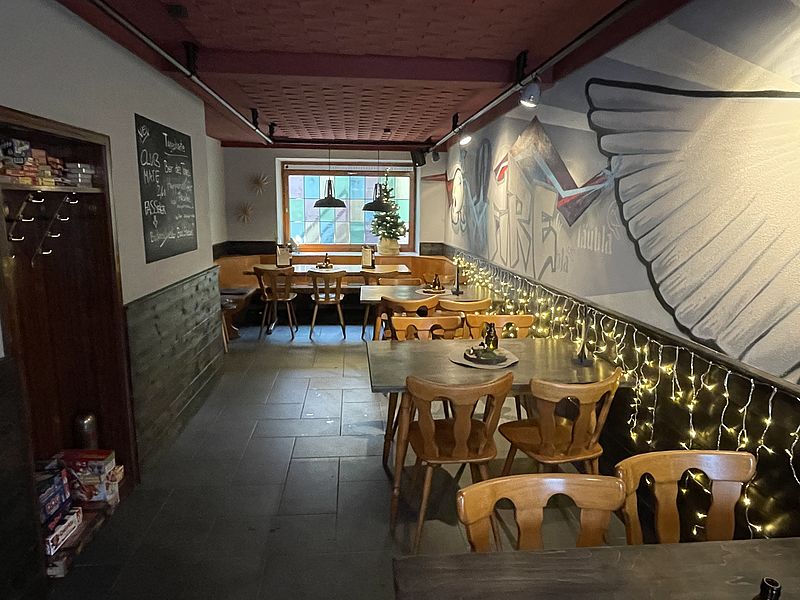 Tische und Stühle stehen in einem Raum mit Graffiti an der Wand