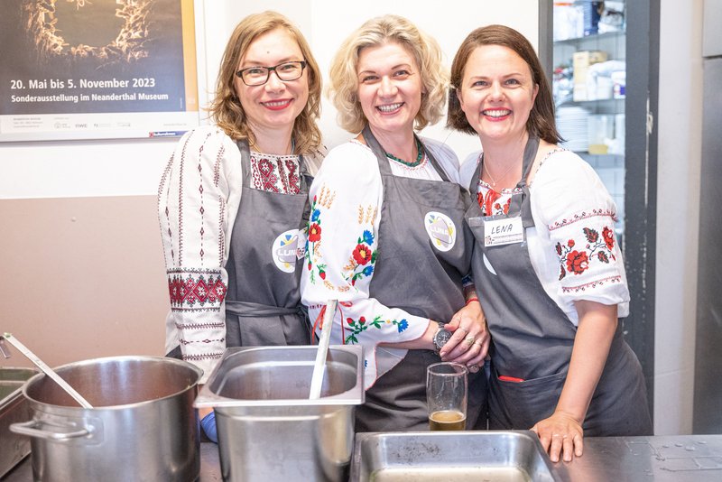 Drei Köchinnen bieten ein Mittagessen an.