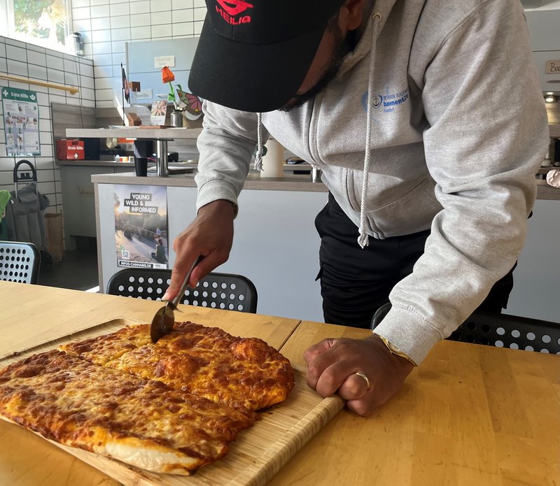 Besucher*innen beim Pizzabacken
