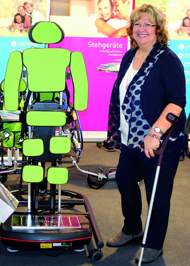 Frau steht mit Krücken neben einem technischen Gerät