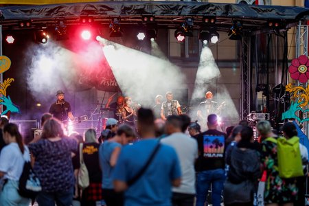Band steht auf der Bühne, viele Menschen schauen zu