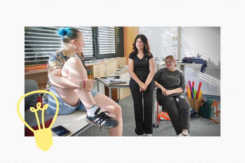 Eine Jugendliche scannt den QR-Code auf einer Werbewand. Darauf steht: Jeder sechste Jugendliche ist von Mobbing betroffen.