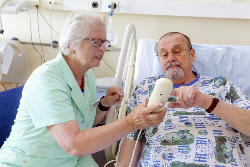 Grüne Dame im Krankenhaus unterstützt Patienten auf dem Weg zur Untersuchung