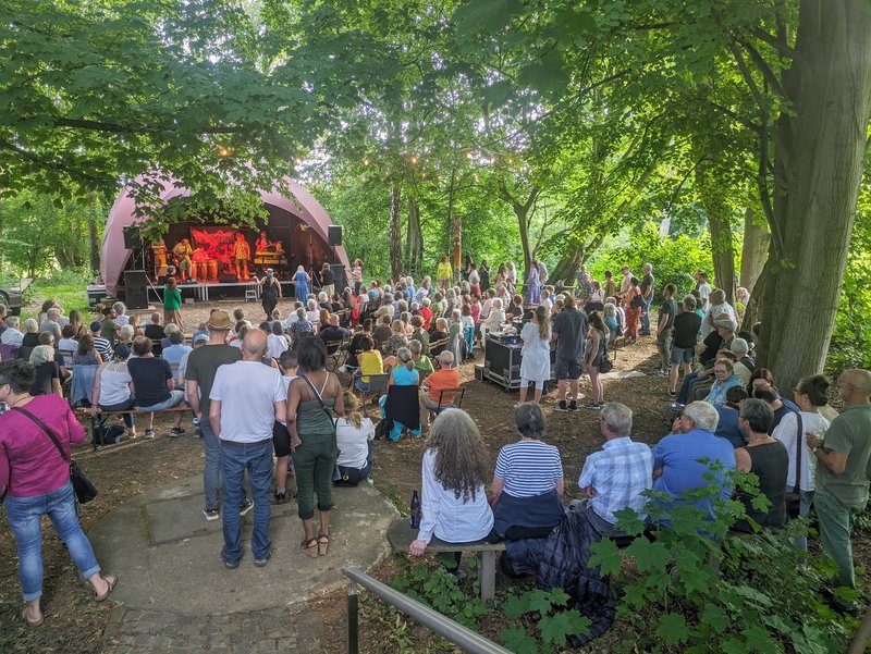 Menschen hören Musik von einer Bühne in der Natur