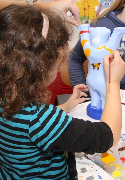 Kind bemalt einen Berliner Bären  